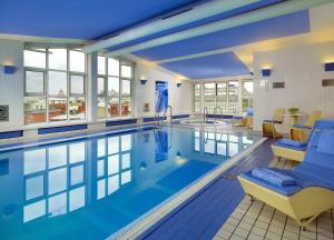 a swimming pool with a blue tub and blue chairs at Hotel National, a Luxury Collection Hotel, Moscow in Moscow