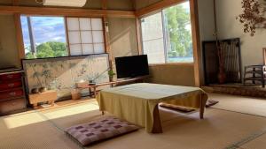 a living room with a table and a tv at Guesthouse Hikobae - Vacation STAY 13657v in Kitakami