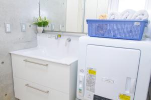 a white refrigerator with a blue basket on top of it at Shiraho Villa - Vacation STAY 13688v in Ishigaki Island +24 photos