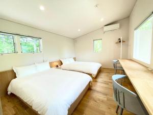 two beds in a room with a desk and two windows at Karuizawa House Villa - Vacation STAY 08359v in Oiwake