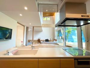 a kitchen with a sink and a kitchen with a living room at Karuizawa House Villa - Vacation STAY 08359v in Oiwake