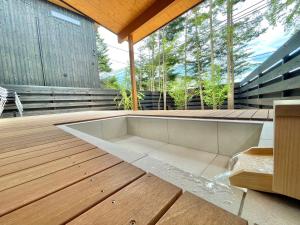 una grande vasca appoggiata su un ponte di legno di Karuizawa House Villa - Vacation STAY 16963v a Oiwake