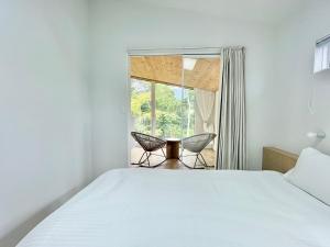 a bedroom with a bed and two chairs and a window at Karuizawa House Villa - Vacation STAY 16955v in Oiwake