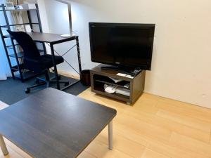 a living room with a tv and a chair and a table at Hamamoto Palace Taniyama - Vacation STAY 10397 in Kagoshima