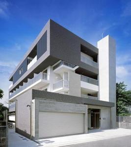 - un grand bâtiment blanc avec un garage en face dans l'établissement Hamamoto Palace Taniyama - Vacation STAY 11965, à Kagoshima