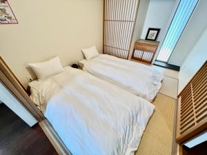 deux lits jumeaux dans une chambre avec fenêtre dans l'établissement Hamamoto Palace Taniyama - Vacation STAY 11965, à Kagoshima