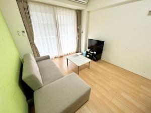 a living room with a couch and a tv at Hamamoto Palace Taniyama - Vacation STAY 11966 in Kagoshima