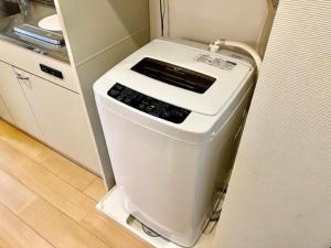 a kitchen with a washing machine in the corner at Hamamoto Palace Taniyama - Vacation STAY 11966 in Kagoshima +7 photos