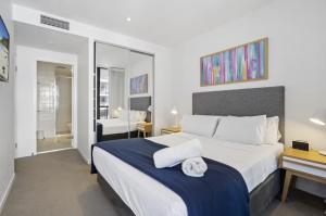 a bedroom with a large bed and a bathroom at Broadbeach 806 in Gold Coast