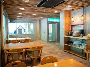 a dining room with wooden tables and chairs at Farm Garden Hotel in Numazu