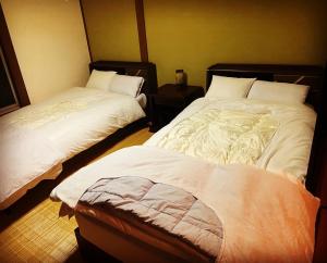 Rural house for rent - Vacation STAY 18282v في Susami: سريرين يجلسان بجانب بعضهما البعض في غرفة