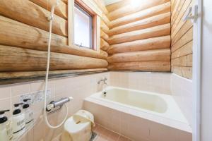 a bathroom with a tub and wooden walls at Shakunagedaira Rental Cottage - Vacation STAY 18468v in Numajiri +14 photos