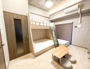 a small room with a bunk bed and a table at Rakuten STAY Fukuoka Yakuin Bunk bed Triple Room in Fukuoka