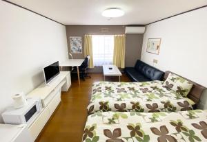 a hotel room with two beds and a desk at Flat piece chair house - Vacation STAY 40366v in Fuzuchi