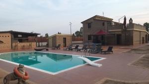 a swimming pool in a patio with chairs and a table at Villa Lemy in Cerasella