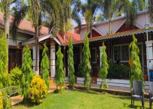 a house with palm trees in the yard at Madhuson Palms in Karjat