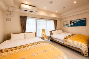 ein Hotelzimmer mit zwei Betten und einem Fenster in der Unterkunft Tomariehoteru & kondominiamu - Vacation STAY 19482v in Hakata