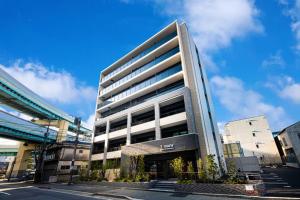 ein hohes Gebäude in einer Stadt mit einem Himmel in der Unterkunft Tomariehoteru & kondominiamu - Vacation STAY 19482v in Hakata