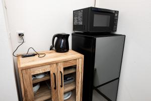 a microwave sitting on top of a black refrigerator at Tomariehoteru & kondominiamu - Vacation STAY 19480v in Hakata