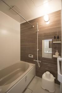 a bathroom with a tub and a toilet and a sink at Guest House Kyoto Mills Benitoan - Vacation STAY 19493v in Kyoto
