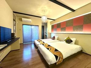 a bedroom with two beds and a flat screen tv at Guest House Kyoto Mills Benitoan - Vacation STAY 19493v in Kyoto