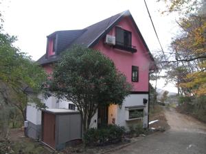 a red and white house with a tree in front at Trust Maison Katase - Vacation STAY 24205v in Izu
