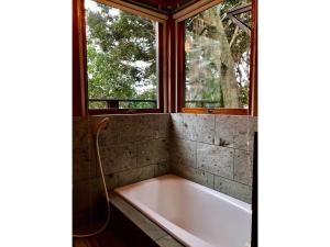 a bath tub in a bathroom with two windows at Trust Maison Atagawa 2 - Vacation STAY 24220v in Okawa +26 photos