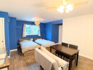 a blue room with two beds and a table at Alaula - Vacation STAY 22838v in Izumi-Sano