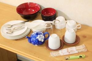 un tavolo con piatti, tazze e utensili sopra di Monthly Mansion Tokyo West 21 - Vacation STAY 10886 a Fuchū Altre 2 foto