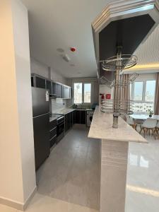 a kitchen with black and white cabinets and a table at new Salalah apartment in Salalah