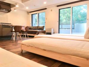 a room with three beds and a couch and a table at Lions Mansion Sapporo Jozankei Sanbankan - Vacation STAY 10917 in Jozankei +69 photos
