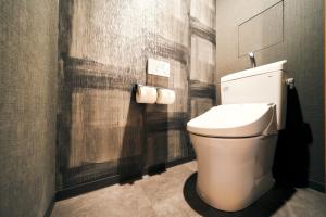 a bathroom with a toilet and two rolls of toilet paper at Rakuten STAY Kyoto Station Twin Room with ceiling projector in Kyoto +31 photos