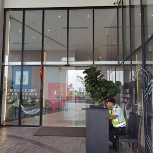 a man sitting in a chair in front of a building at Amber Cove in Malacca +16 photos