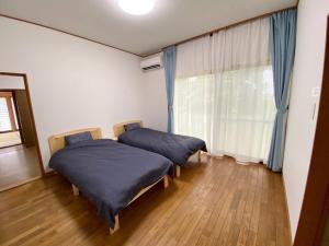 two beds in a room with a window at Haru no Sato - Vacation STAY 10683 in Kido