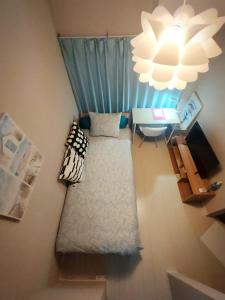 a room with a couch and a table and a chandelier at MeMe Inn - Vacation STAY 10897 in Saitama