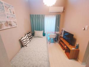 a room with a bed and a desk and a television at MeMe Inn - Vacation STAY 10897 in Saitama
