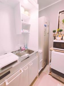 さいたま市にあるMeMe Inn - Vacation STAY 10899のシンクと冷蔵庫を備えた白いキッチン