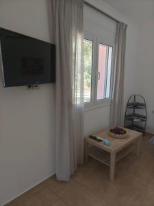 a living room with a tv and a table and a window at Rias Efthimiou House in Kanallaki