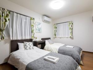 a bedroom with two beds and a desk and window at Maesato-Kodate Ocean Front Maesato - Vacation STAY 23748v in Ishigaki Island