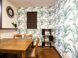 a dining room with a table and a wall covered in wallpaper at Maesato-Kodate Ocean Front Maesato - Vacation STAY 23748v in Ishigaki Island