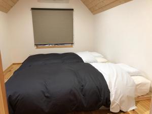a bedroom with a bed with a black and white comforter at Nikko, Matsubara no Yado - Vacation STAY 31914v in Nikko
