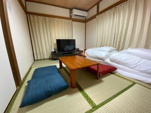 ein Zimmer mit einem Bett, einem Tisch und einem Fernseher in der Unterkunft wonderful stay TOKYO Daitabashi - Vacation STAY 31675v in Tokio
