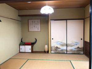 Cette chambre est dotée d'une grande porte en verre avec une peinture sur le mur. dans l'établissement Trust Maison Hokkawa - Vacation STAY 24200v, à Okawa