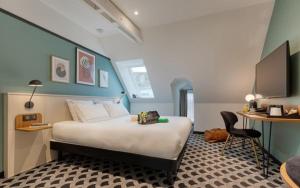 a bedroom with a bed and a desk and a chair at Brit Hotel Les Voyageurs in Loudéac