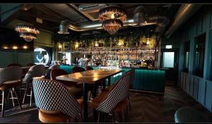 a restaurant with a bar with a wooden table and chairs at Larch View in Tattershall