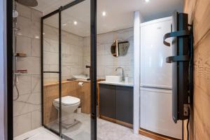 a bathroom with a toilet and a sink and a refrigerator at L'Escampette à la Fontanette in Saint-Pancrace +22 photos