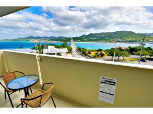 a balcony with a table and chairs and a view of the water at Ocean Terrace Sesoko 101 - Vacation STAY 28609v in Ufugumui