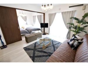 a living room with a couch and a glass table at Ocean Terrace Sesoko 101 - Vacation STAY 28609v in Ufugumui