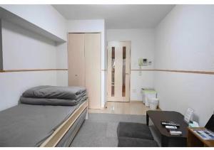 a bedroom with a bed and a desk and a table at Marvelous Kokubunji - Vacation STAY 29877v in Kokubunji