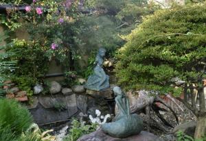 due statue in un giardino con una cascata di Kōnotori no sato no yado - Vacation STAY 11112 a Kōnosu Altre 10 foto